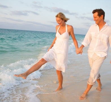 Couple walking on the beach by the water